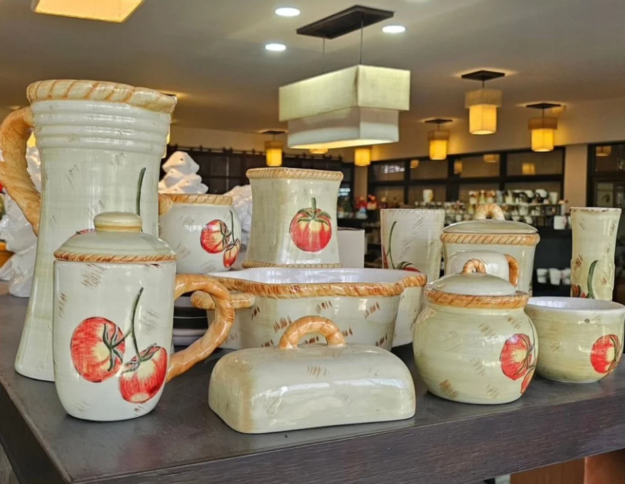 A hand-painted tomato ceramic set: jug, canisters, butter dish and bowls